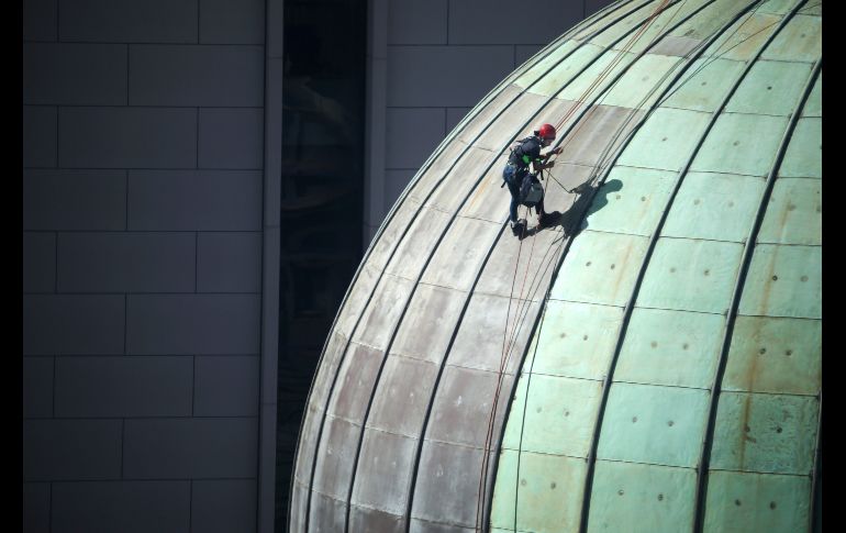 Un hombre realiza labores de mantenimiento en el domo del edificio Reina Victoria en Sídney, Australia. AP/R. Rycroft
