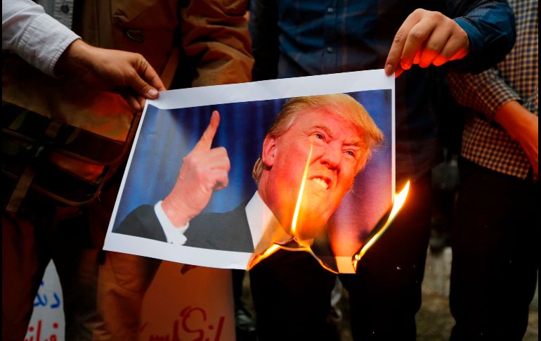 Iraníes queman una imagen del presidente estadounidense Donald Trump en una protesta afuera de la ex embajada estadounidense en Teherán, en una manifestación contra Estados Unidos luego de que éste anunció el retiro del acuerdo nuclear con Irán. AFP/A. Kenare