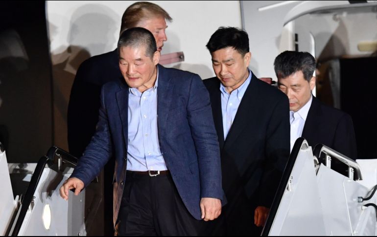 Kim Dong-chul, Kim Sang-duk y Kim Hak-song descienden del avión. AFP/N. Kamm