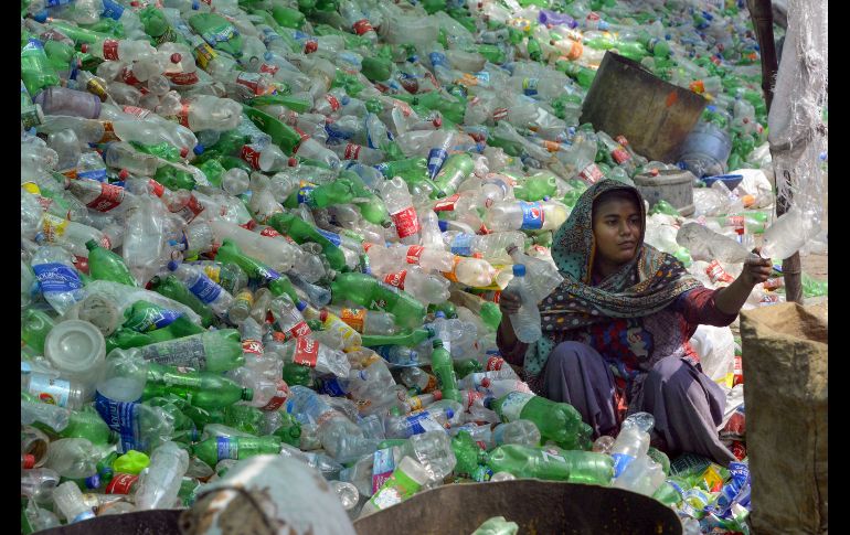 Una trabajadora acomoda botellas de plástico en un almacén en Lahore, Pakistán. AFP/A. Ali