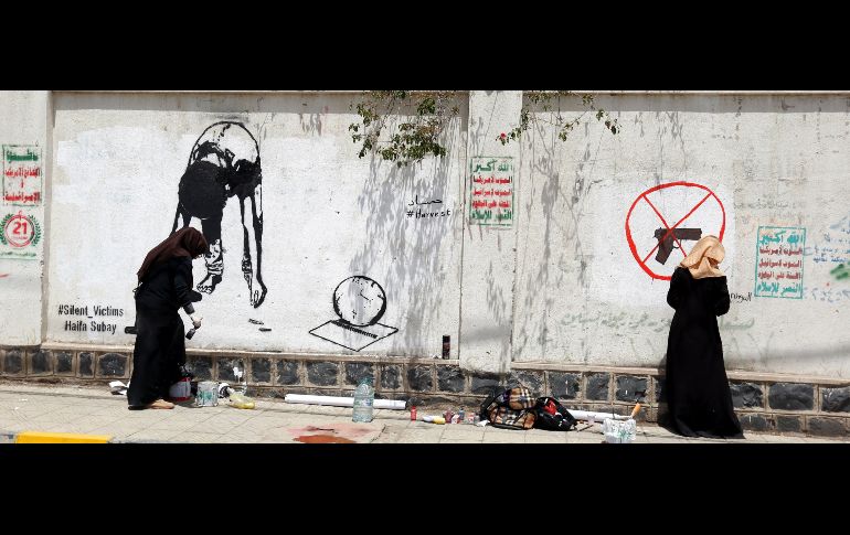 La artista yemení Haifa Subay pinta un mural protesta contra el reclutamiento militar infantil en Saná, Yemen. EFE/ Y. Arhab