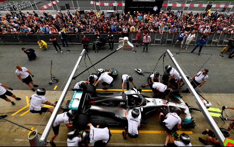 Mecánicos de la escudería Mercedes practican el cambio de neumáticos en el monoplaza de Lewis Hamilton, previo al inicio del Gran Premio de España. AFP/P. Marcou