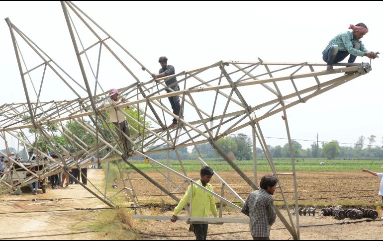 Trabajadores indios retiran una torre de transmisión eléctrica dañada que colapsó durante una tormenta en la aldea de Ibban Kallan, a las afueras de Amritsar. AFP/N. Nanu
