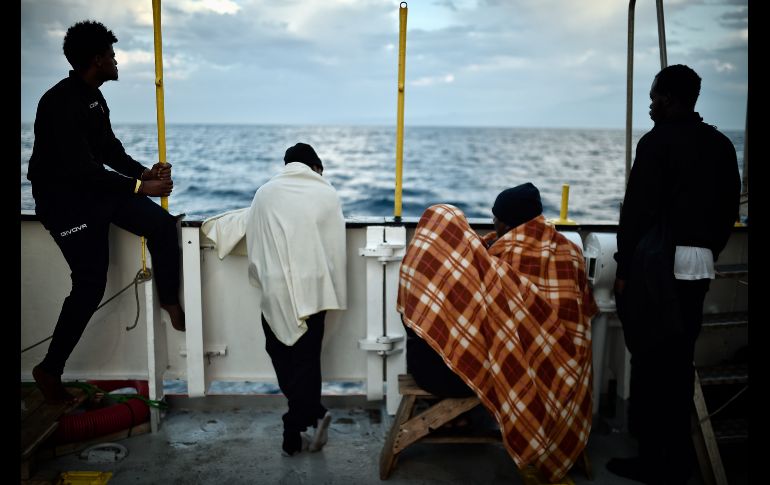 Migrantes se ven en un barco cerca de la costa de Sicilia, Italia, tras ser rescatados el fin de semana. AFP/L. Gouliamaki