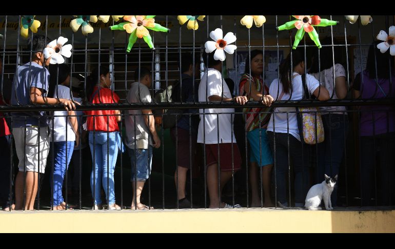 Votantes hacen fila en un casilla en ciudad Quezon, Filipinas, en el marco de las elecciones locales en casi 42 mil poblaciones.  AFP/T. Aljibe