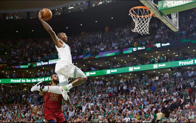 De postal. Terry Rozier se eleva por los aires para clavar el balón ante la mirada del astro de los Cavaliers, LeBron James. AP