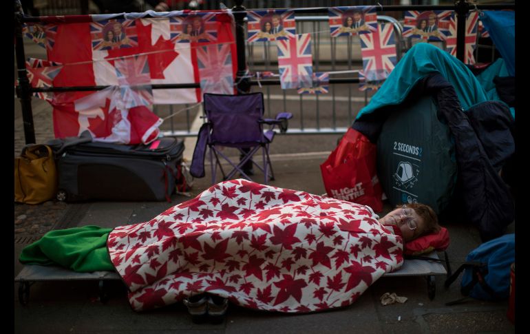 Una mujer duerme afuera del castillo de Windsor, en Inglaterra, donde aguarda para ver al príncipe Enrique y la actriz Meghan Markle, que se casarán en el castillo el próximo sábado. AP/E. Morenatti