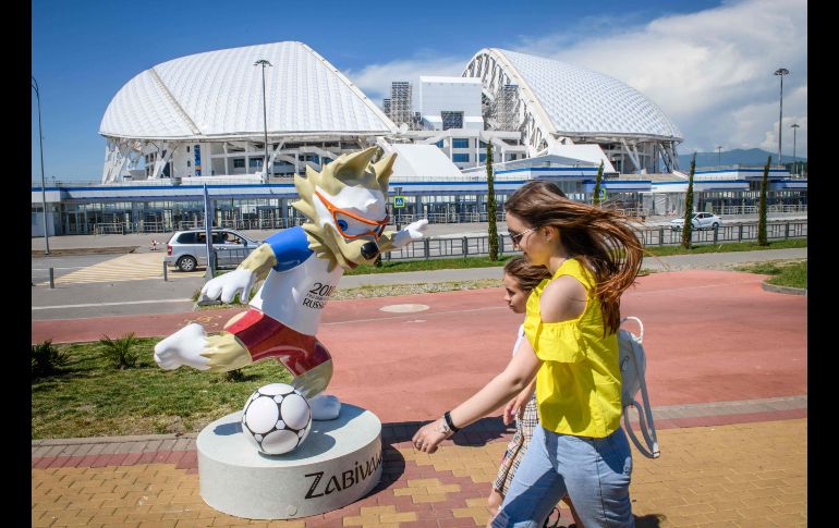 Mujeres pasan frente al estadio olímpico Fisht en Sochi, Rusia. El inmueble albergará seis encuentros de la Copa del Mundo de Rusia. AFP/M. Antonov