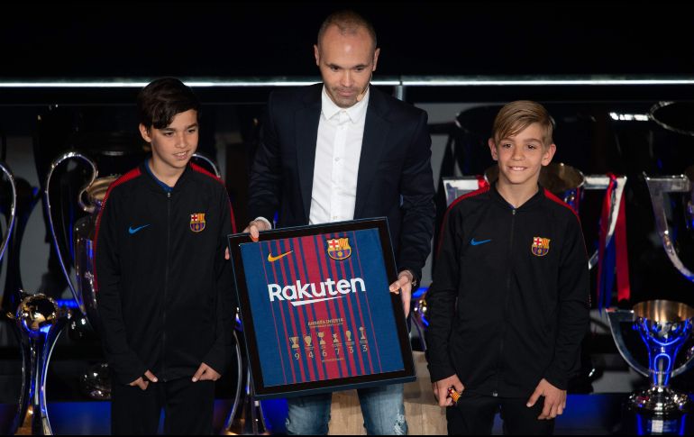 Iniesta, un símbolo del Barcelona, apareció acompañado por dos jóvenes miembros del club. AFP/J. Lago