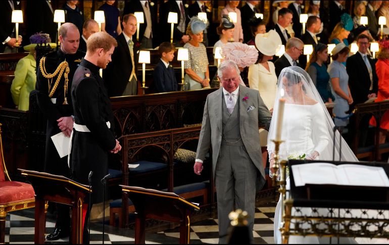 Meghan Markle caminó hacia el altar de la Capilla de San Jorge tomada del brazo del príncipe Carlos para reunirse con el príncipe Enrique, quien sonriente la miró y le dijo 