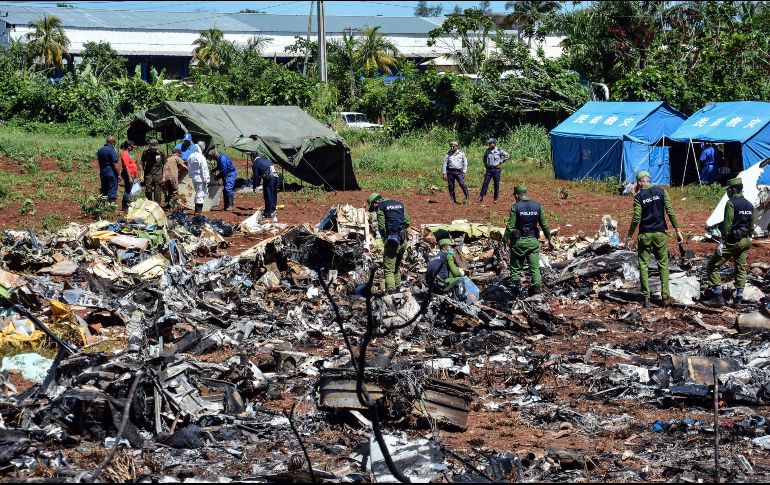 Policías trabajan hoy entre los escombros del avión accidentado. Todos los restos humanos ya fueron recogidos del sitio donde la nave se desplomó en un campo sembrado colindante con el aeropuerto José Martí. EFE/M. Vázquez