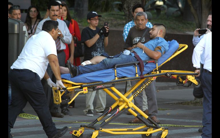 Un hombre lesionado en el tiroteo es trasladado por personal de emergencias. AFP/U. Ruiz