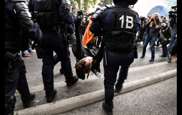 Un hombre inconsciente es evacuado y arrestado por policías tras una manifestación en París, en el marco de una jornada nacional de protesta de servidores públicos en contra de las reformas propuestas por el presidente Emmanuel Macron. AFP/E. Feferberg