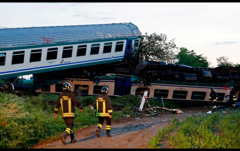 Bomberos inspeccionan los vagones de un tren descarrilado en Caluso, Italia. Dos personas murieron y más de 20 resultaron heridas. AP/A. Calanni