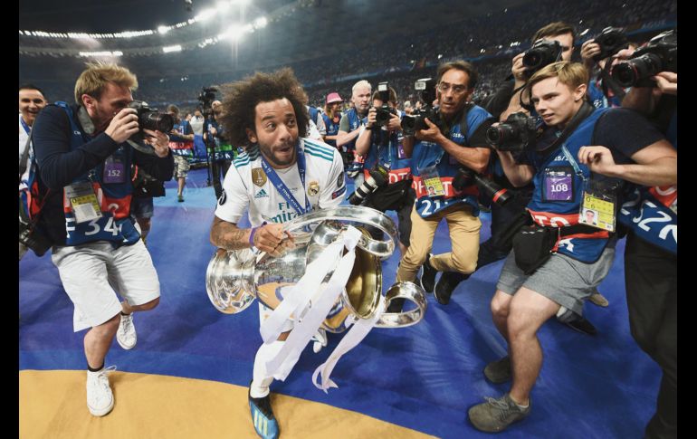 El lateral derecho madridista Marcelo se escapa con la “Orejona” conquistada ayer en Kiev, tras derrotar por tres goles a uno al Liverpool, con lo que el Real marca la hazaña del triplete en Champions League.