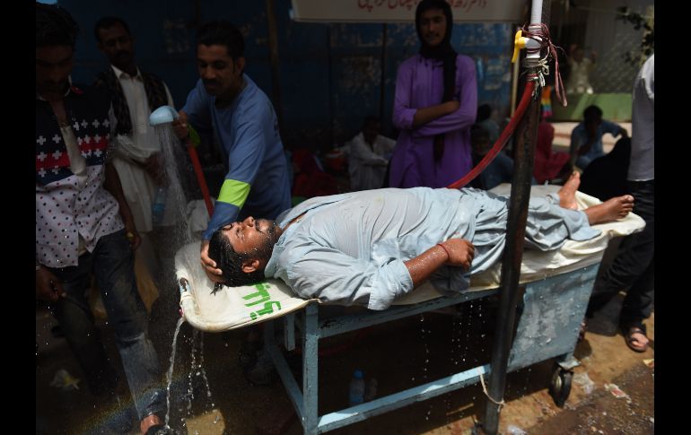 Un voluntario echa agua a un hombre durante una ola de calor en Karachi, Pakistán. Autoridades han lanzado alertas por las altas temperaturas, que en el día van de los 40 a los 44 grados centígrados. AFP/R. Tabassum