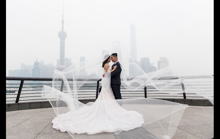 Una pareja posa para un fotógrafo de bodas junto al río Huangpu, en el distrito financiero Lujiazui de Shanghái, China. AFP/J. Eisele