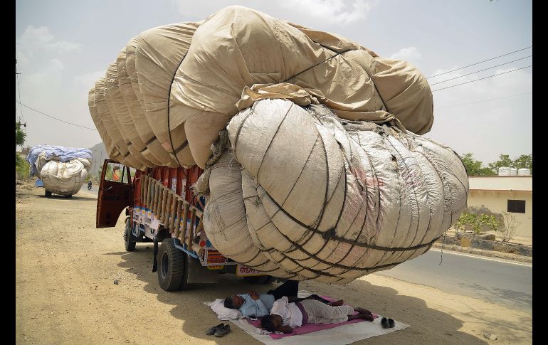 Hombres descansan bajo la sombra de heno envuelto en tela, durante un día caluroso en Ajmer, India. AFP/S. Ahmed