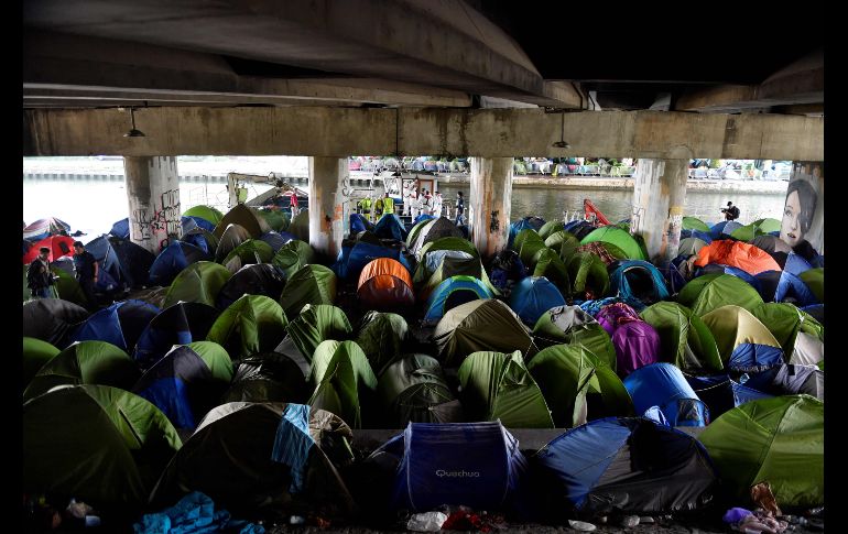Trabajadores llegan para limpiar un campamento de migrantes junto al Canal Saint-Denis, en el norte de París, Francia, luego de que la policía evacuara a sus más de mil ocupantes. AFP/G. Julien