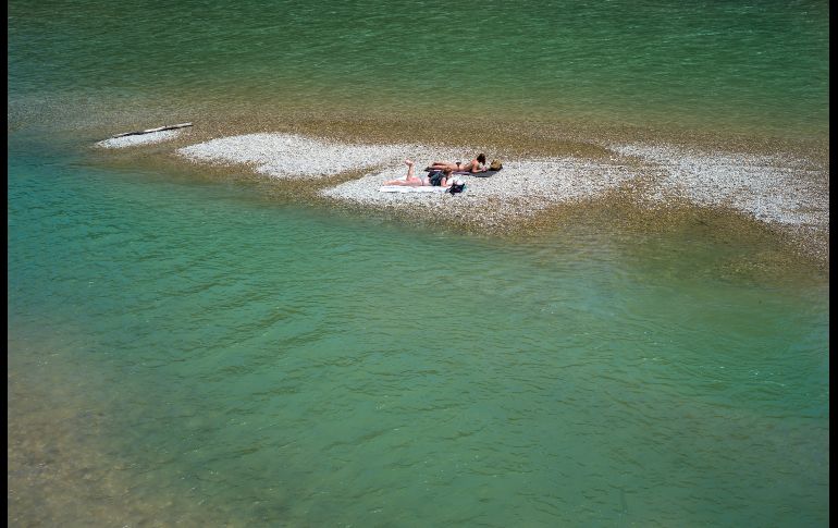 Mujeres toman el Sol en un banco de grava en el río Isar, en la ciudad alemana de Munich. AFP/DPA/P. Kneffel