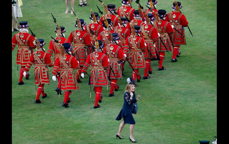 Una invitada reacciona tras tomar fotos de soldados en el Palacio de Buckingham en Londres, Inglaterra, en el marco de una fiesta organizada por la reina Isabel II. AP/F. Augstein