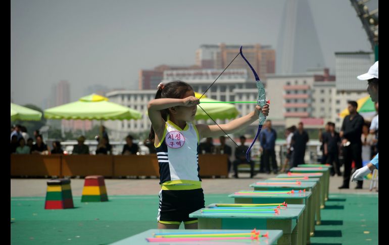 Una niña juega con un arco y flecha durante una celebración del Día internacional del niño, realizada en un parque de Pyongyang, Corea del Norte. AFP/W. Kim