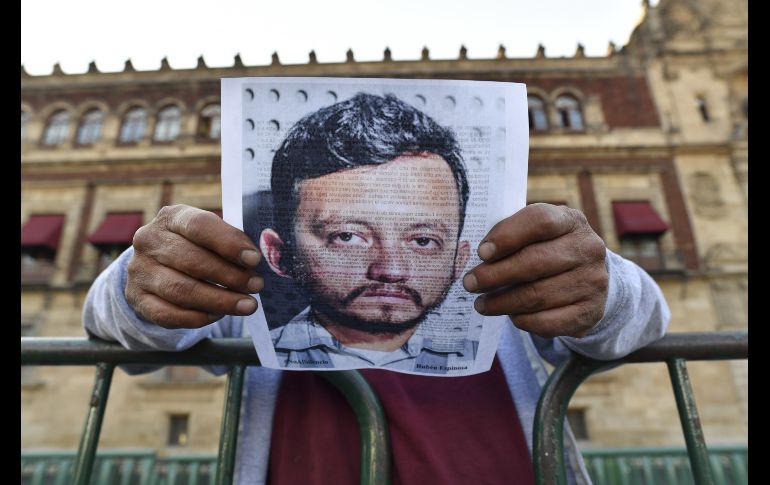Un transeúnte lee un comunicado de los manifestantes con una imagen del fotoperiodista Rubén Espinosa, asesinado en 2015. AFP/Y. Cortez