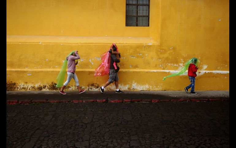 Una familia se protege de la caída de ceniza en Antigua Guatemala, Sacatepéquez. EFE/E. Biba