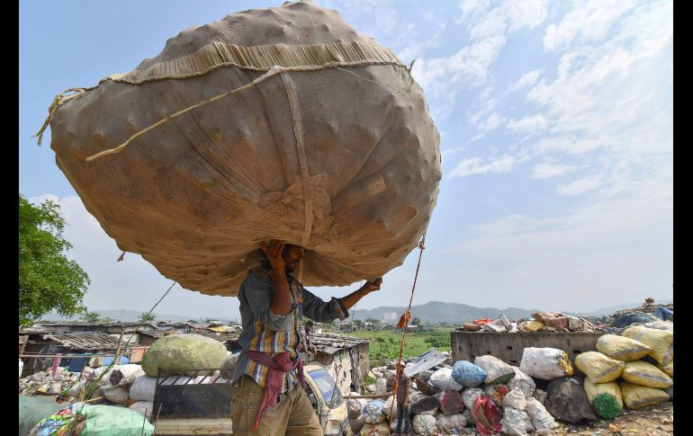 Un trabajador carga un saco de botellas de plástico en Boragaon, cerca de uno de los mayores basureros en el noreste de la India. AFP/B. Boro