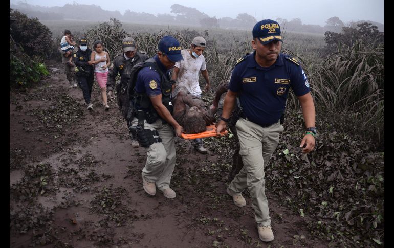 Policías evacuan a un herido y pobladores en El Rodeo. AFP/N. Pérez