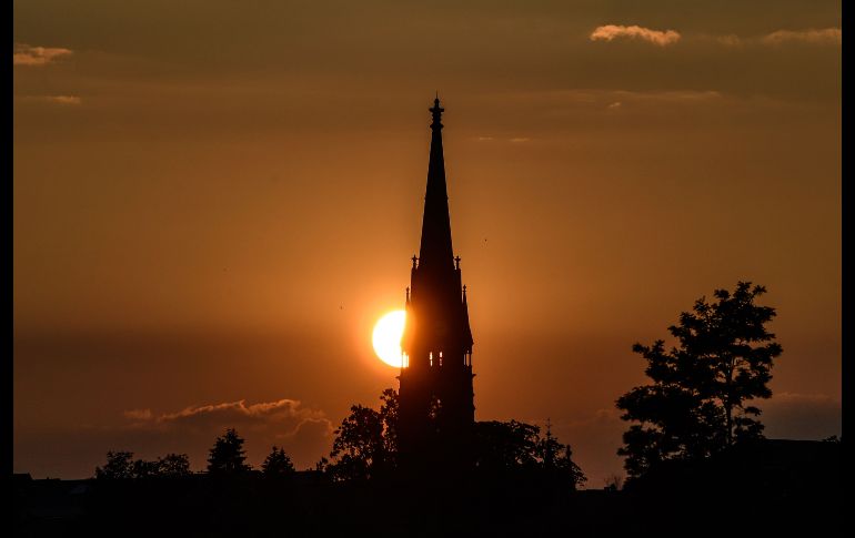 El Sol está a punto de ocultarse detrás de la torre de la iglesia Martin Luther, en Dresde, Alemania. EFE/F. Singer