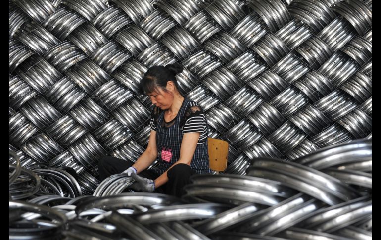 Una trabajadora revisa piezas de carriolas de exportación en una fábrica en Hangzhou, China. AFP
