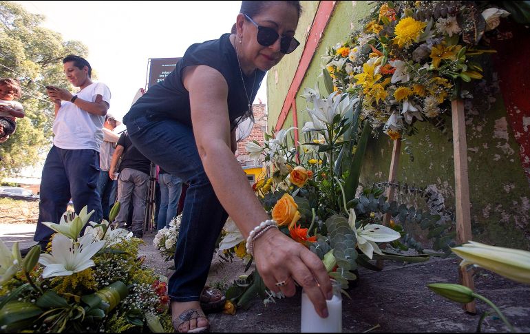 Ramilletes y veladoras se acumularon a las puertas del albergue, que está bajo resguardo policial desde 2014. EFE/I. Villanueva