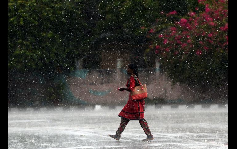 Una habitante camina durante una fuerte lluvia en Chennai, India. AFP/A. Sankar