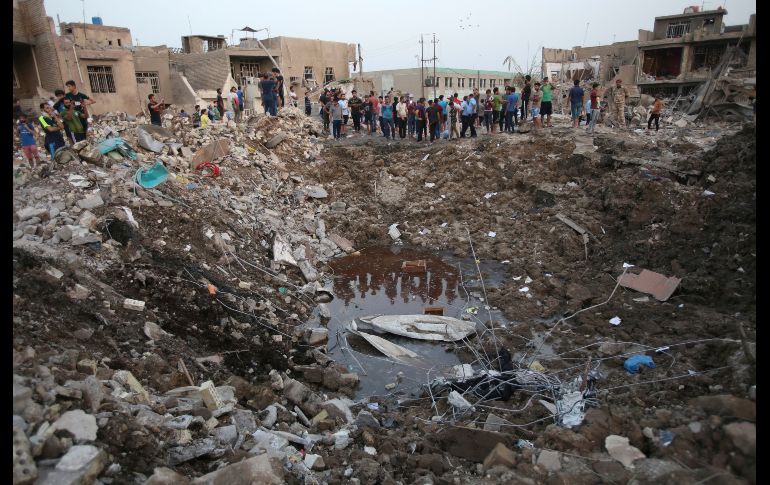 Civiles observan el sitio de explosiones en Ciudad Sadr, a las afueras de la capital iraquí. La detonación ayer de un alijo de municiones dejó al menos 20 muertos y 130 heridos. AP/K. Kadim