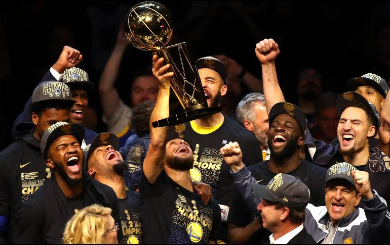 Los Warriors posan junto con el trofeo de campeones, en medio de un ambiente de alegría. AFP/J. K. Aller