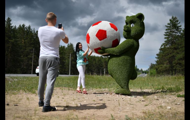Una mujer posa para una foto junto a una escultura de hojas alusiva a la Copa del Mundo 2018, cerca del aeropuerto de Samara, Rusia. AFP/F. Coffrini