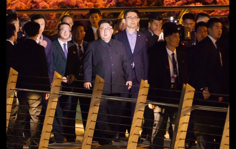 El líder norcoreano, Kim Jong-un (c), camina junto a su comitiva durante una visita al puente Jubilee en la Esplanada de Singapur. El presidente estadounidense, Donald Trump, y Kim Jong-un se reunirán mañana en una cumbre en Singapur. AFP/N. Yeo