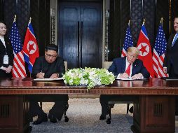 El presidente estadounidense, Donald J. Trump (d), y el líder norcoreano, Kim Jong-un, firman una declaración conjunta durante su histórica cumbre de más de cuatro horas. EFE/K. Lim