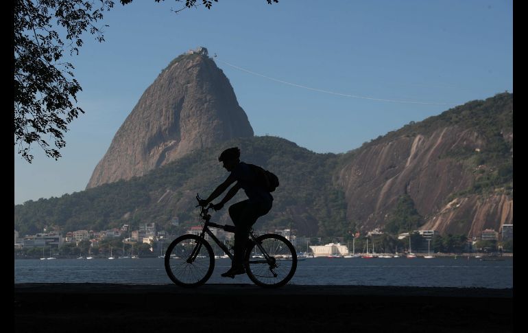 Un ciclista cruza por la ensenada de Botafogo, con el Pan de Azúcar al fondo, en Río de Janeiro, Brasil. El principal congreso internacional sobre ciclismo y movilidad urbana, Velo-city 2018, se inauguró hoy en la ciudad. EFE/M. Sayão