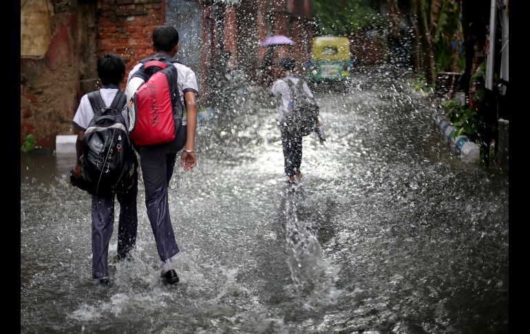 Un grupo de niños juega bajo la lluvia en Calcuta, India. Una serie de tormentas y lluvias monzónicas han interrumpido el trascurso normal de la vida en esta región. EFE/ P. Adhikary