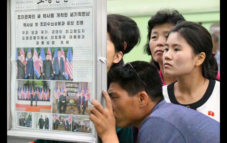 Norcoreanos observan en Pyongyang una página de un periódico local sobre la cumbre entre el líder norcoreano Kim Jong-Un y el presidente estadounidense Donald Trump. AP/Kyodo News/M. Iwasaki