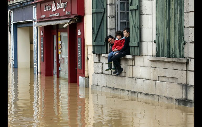 Una mujer y sus hijos observan el nivel de una calle inundada por fuertes lluvias en Salies-de-Bearn, ciudad del sur de Francia. AP/B. Edme