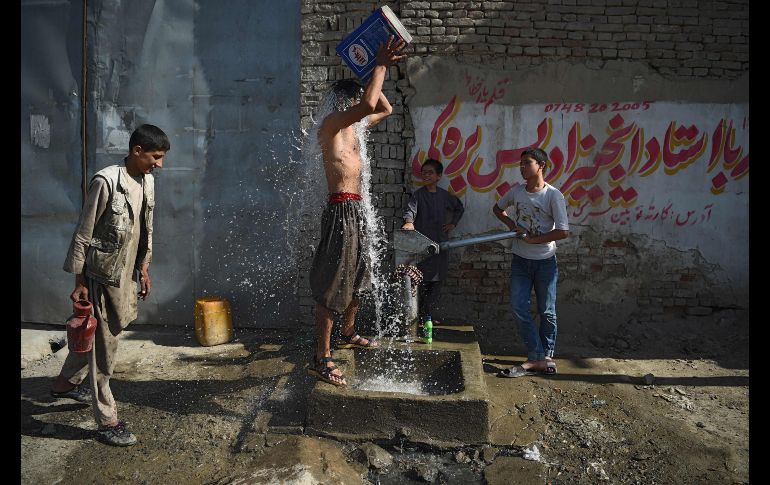 Un joven se refresca junto a una bomba de agua en Kabul, Afganistán. AFP/W. Kohsar