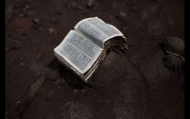 Una biblia rescatada se ve colocada sobre una piedra.