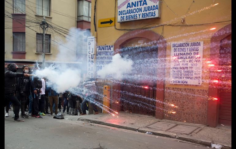 Estudiantes lanzan fuegos artificiales a policías en La Paz, Bolivia, durante protestas para exigir un aumento en el presupuesto de las universidades públicas. AP/J. Karita