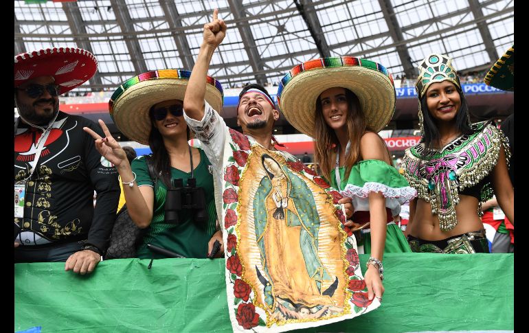 Un aficionado porta la imagen de la Virgen de Guadalupe en las tribunas. AFP / J. Mabromata