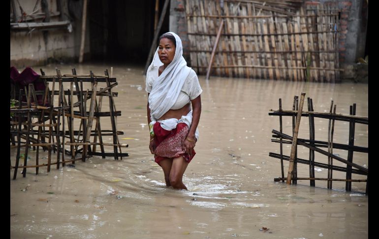 Una mujer camina por una zona inundada tras fuertes lluvias en Kampur, en la región india de Assam, donde han muerto al menos cuatro personas por las inundaciones. AFP/B. Boro