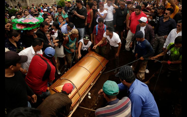 Varios hombres ayudan a sostener el féretro de una de las víctimas de la familia que murió ayer calcinada, en Managua, Nicaragua. Siete miembros de una familia murieran por un incendio provocado en el marco de las protestas contra el Gobierno. EFE/R. Sura