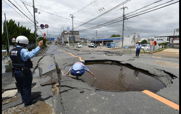 Policías revisan los daños en una vialidad en Takatsuki, Japón, tras un sismo de magnitud 6.1 al norte de Osaka. Al menos tres personas murieron y más de 300 resultaron heridas. AFP/Jiji Press